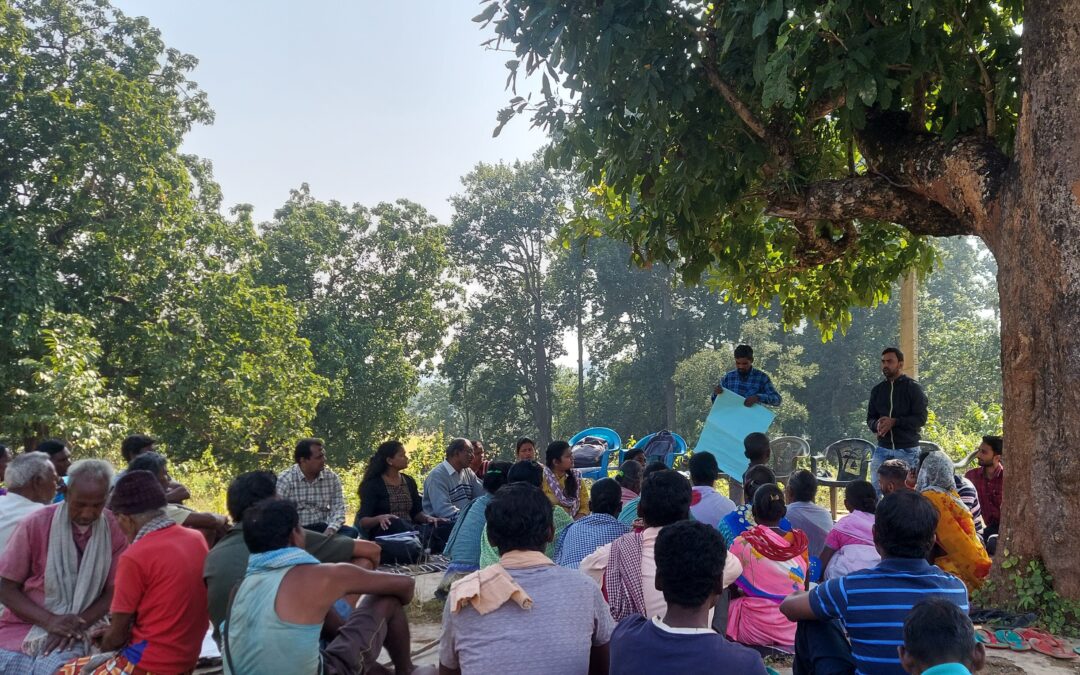 WELL Labs members sit along with villagers under a tree, interacting with a rural community in Jharkhand