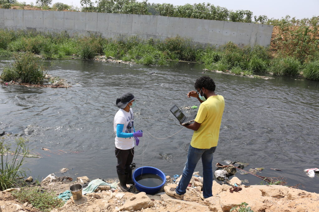 WELL Labs researchers testing a sample of water from Bellandur Lake, Bangalore, in 2021. Credit: Shashank Palur