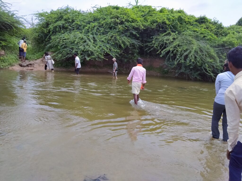 WELL Labs team crossing a shallow waterway on foot in Raichur