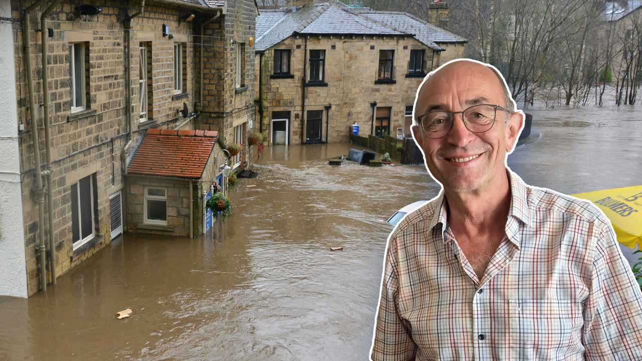 Guenter Bloeschl in the foreground, with a brown brick building in Europe half under floodwater in the background.