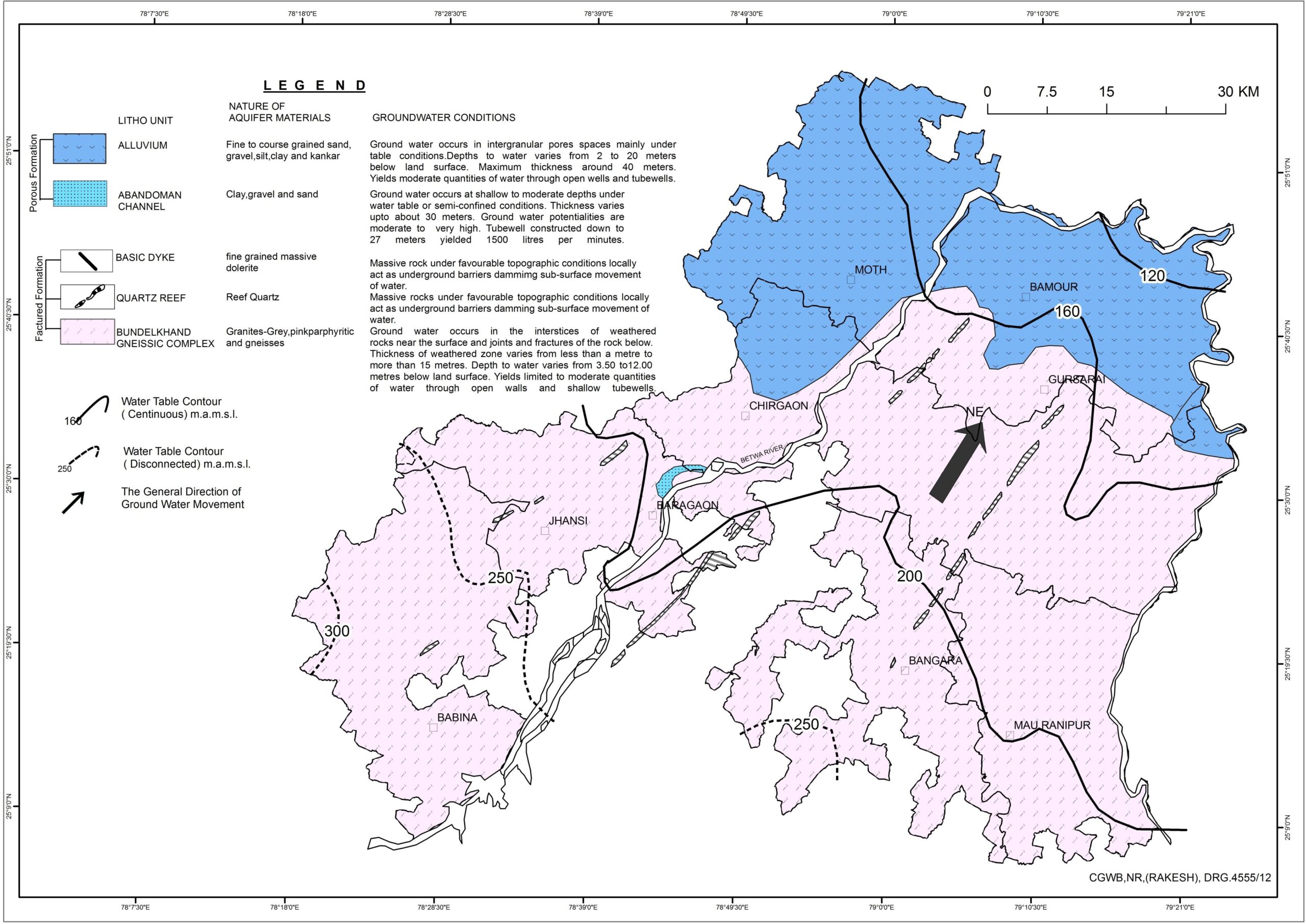 Multiple people stand and sit on the floor of a small building. The floor is covered with red-hued carpets and some red plastic chairs. The walls have posters in Devanagari script. 